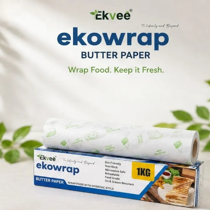 Ekvee Ekowrap Butter Paper roll displayed above its retail box on a light background with decorative green leaves. The packaging is blue and white with a yellow '1KG' label.