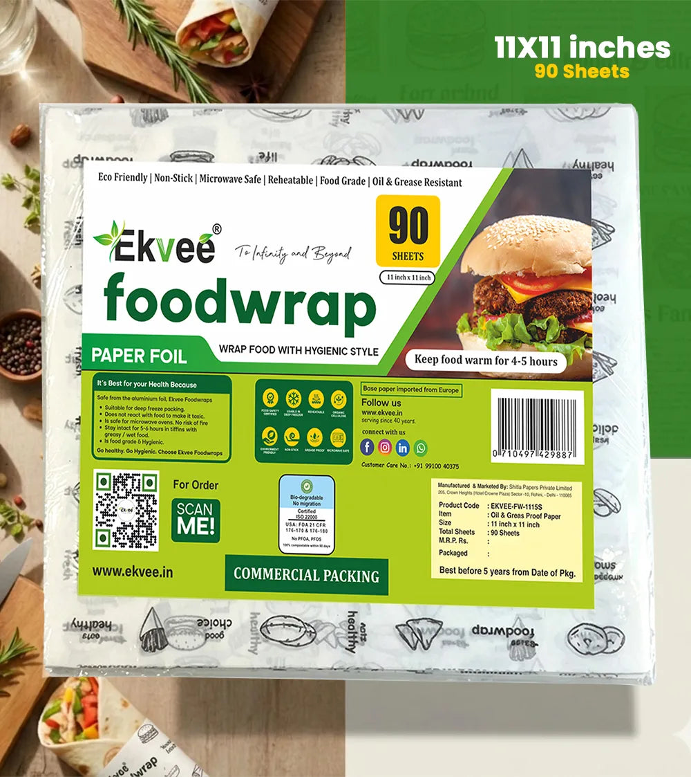 A package of Ekvee Paper Foil Wrap Food, shown in its commercial packaging with a green and white design, featuring a burger graphic and product details. The packaging is set against a styled kitchen background with food props, and a green text overlay in the top right reads '11x11 inches 90 Sheets'.