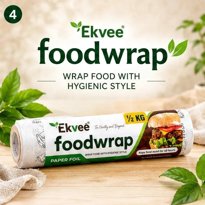 Ekvee Foodwrap paper foil roll displayed on a wooden surface with green leaves and a cloth, featuring product branding and text 'Wrap Food with Hygienic Style'.